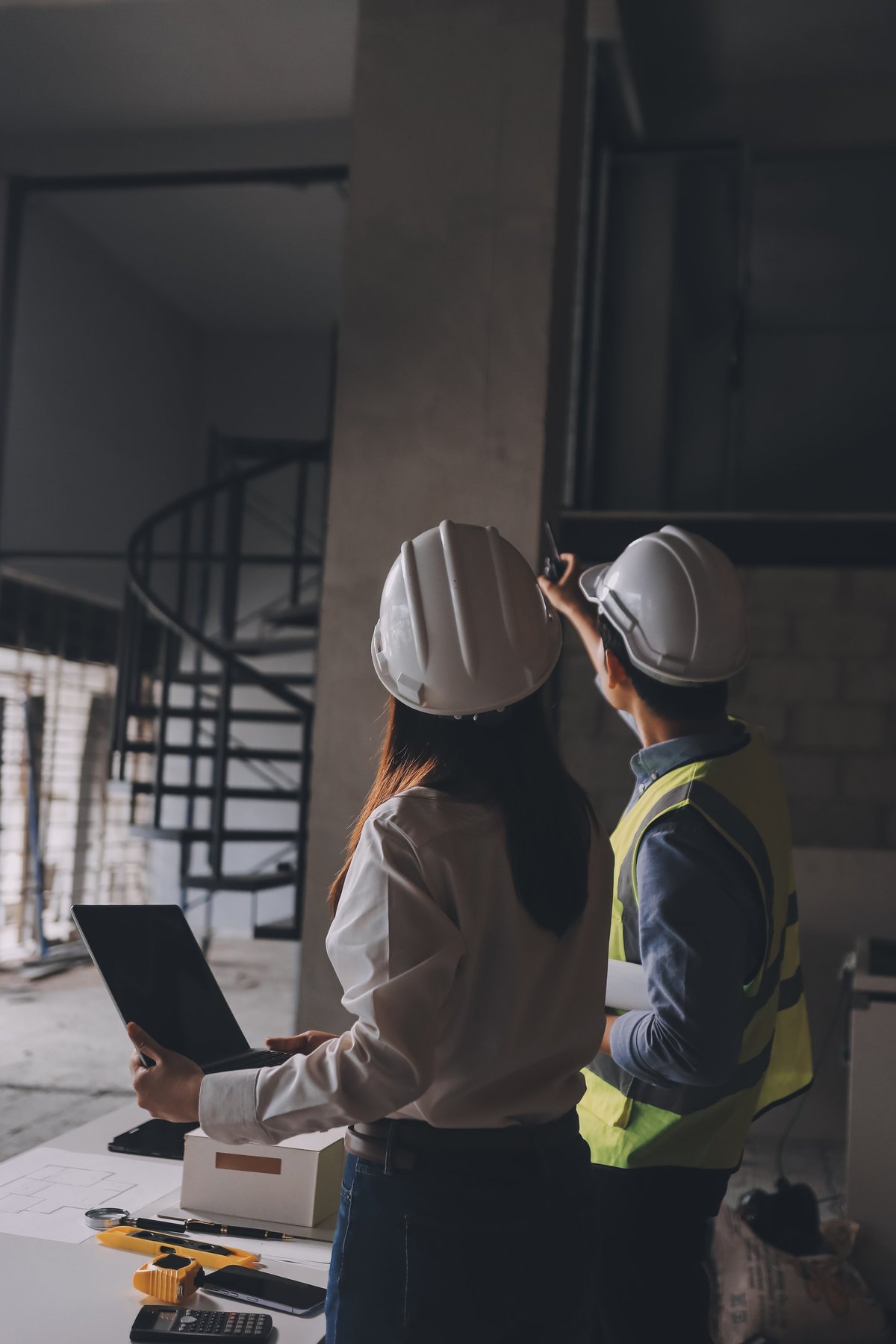 Construction manager and engineer reviewing project documentation on site